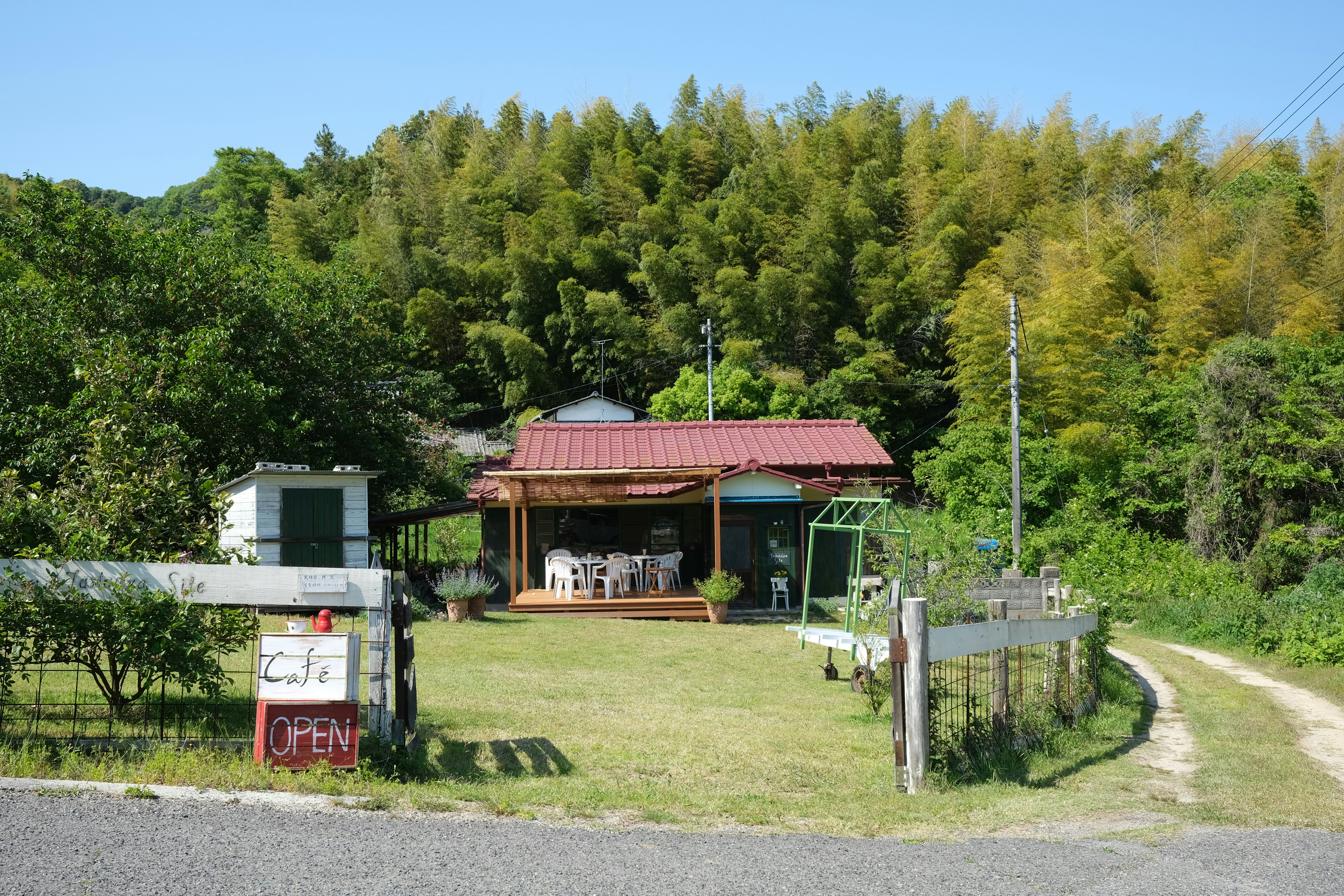 white and red wooden shed near green trees during daytime